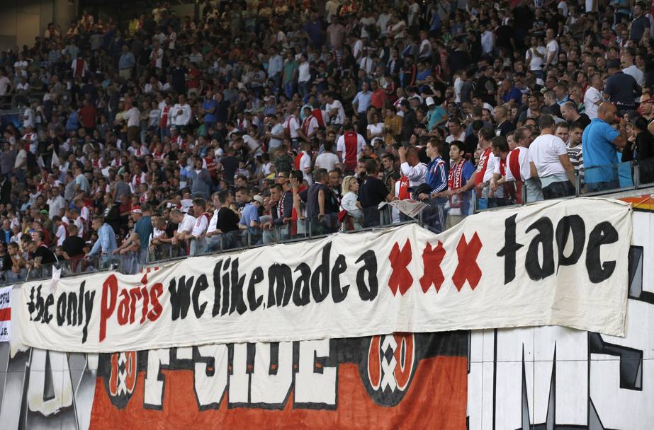 Atmosfera goliardica all&#39;ArenA stadium di Amsterdam. I tifosi dell&#39;Ajax espongono uno striscione di sfott per i rivali francesi del PSG. 